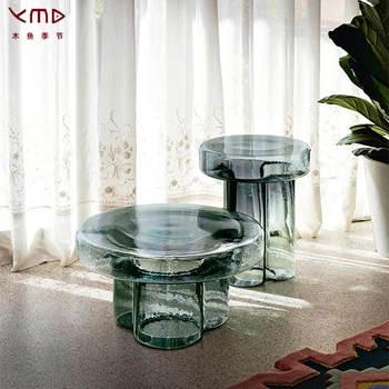 Гостиная в скандинавском стиле небольшого размера с несколькими закругленными краями и несколькими чайными столиками из комбинированного стекла в виде лепестков